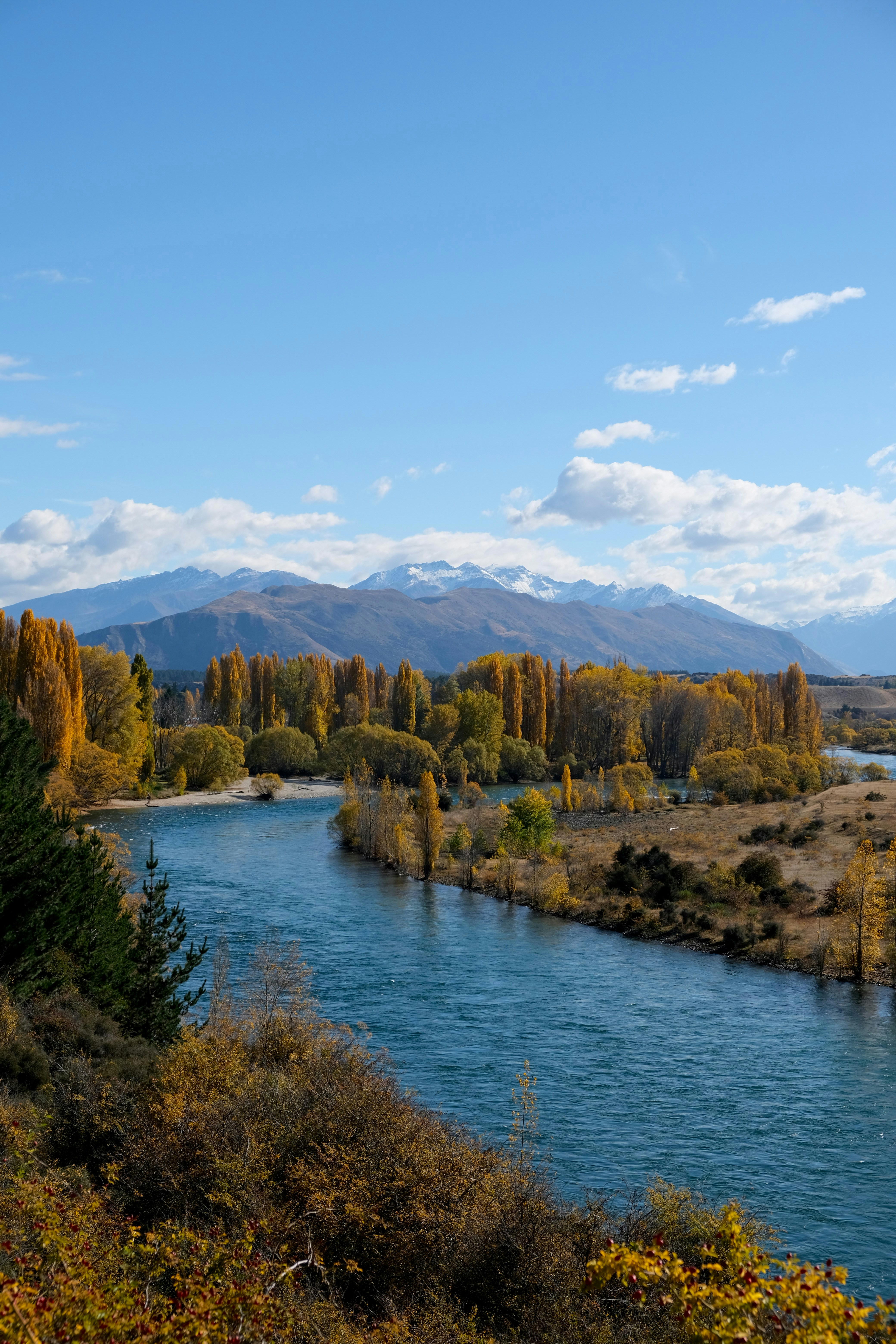 Autumn landscape with a river, trees and mountains
