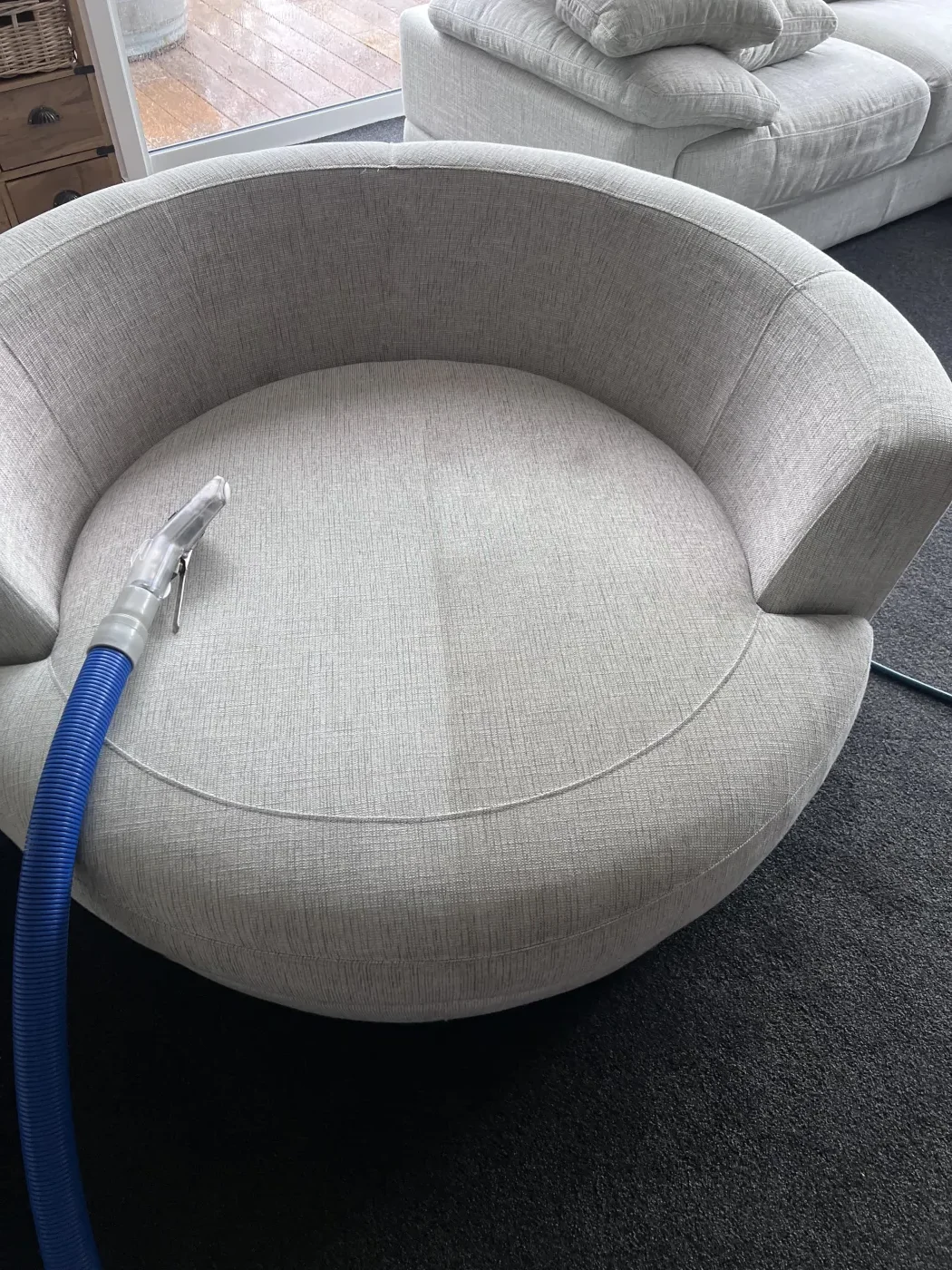 Close view of an upholstered chair being cleaned