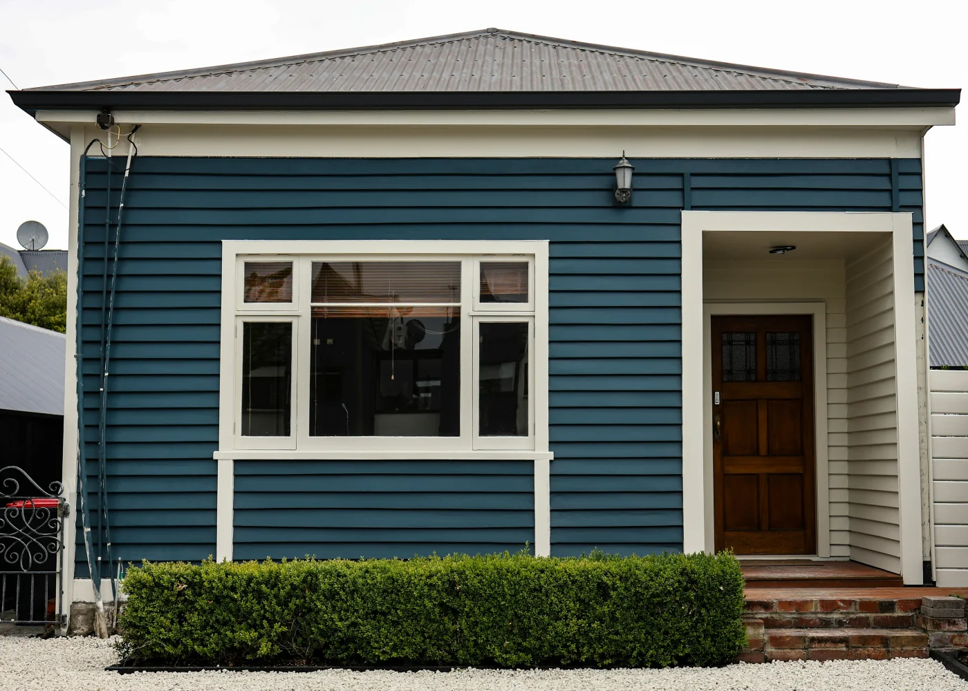 Blue weatherboard home with large front windows and an entryway